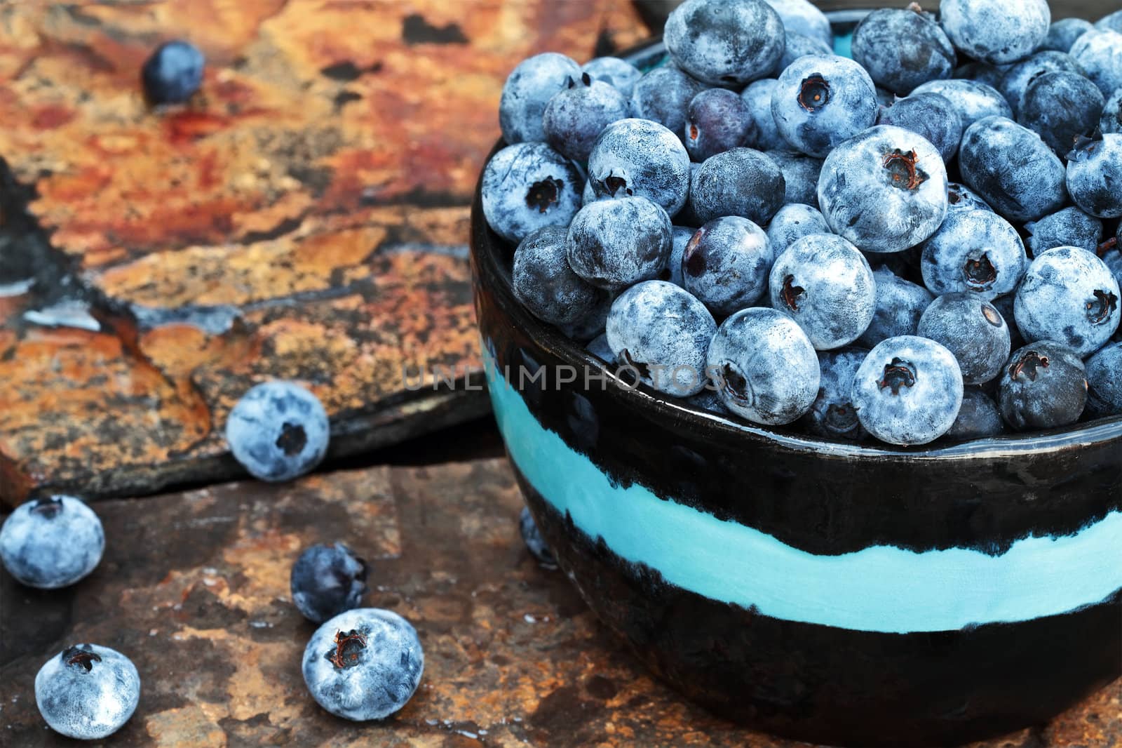 Fresh piced organic blueberries on a rustic slate background.