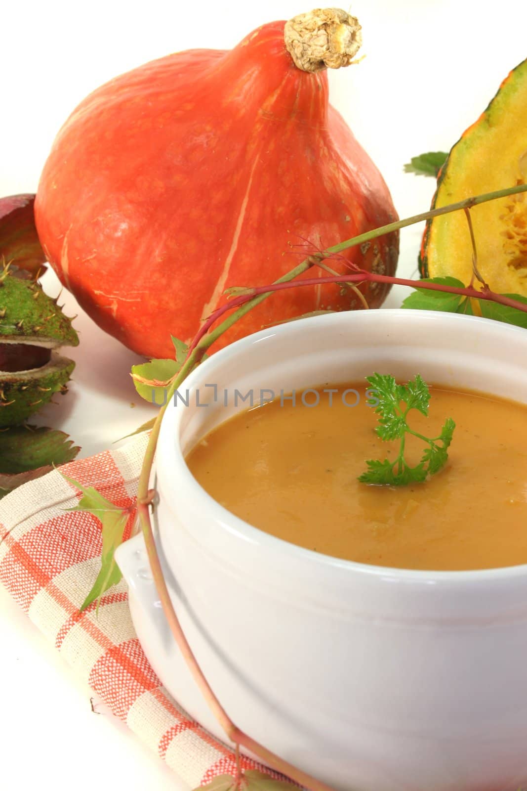 Pumpkin cream soup with fresh Hokkaido pumpkin and autumn leaves