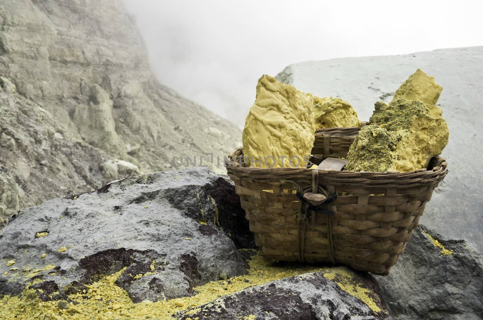 Basket full of sulfur nuggets atop a volcano in Indonesia