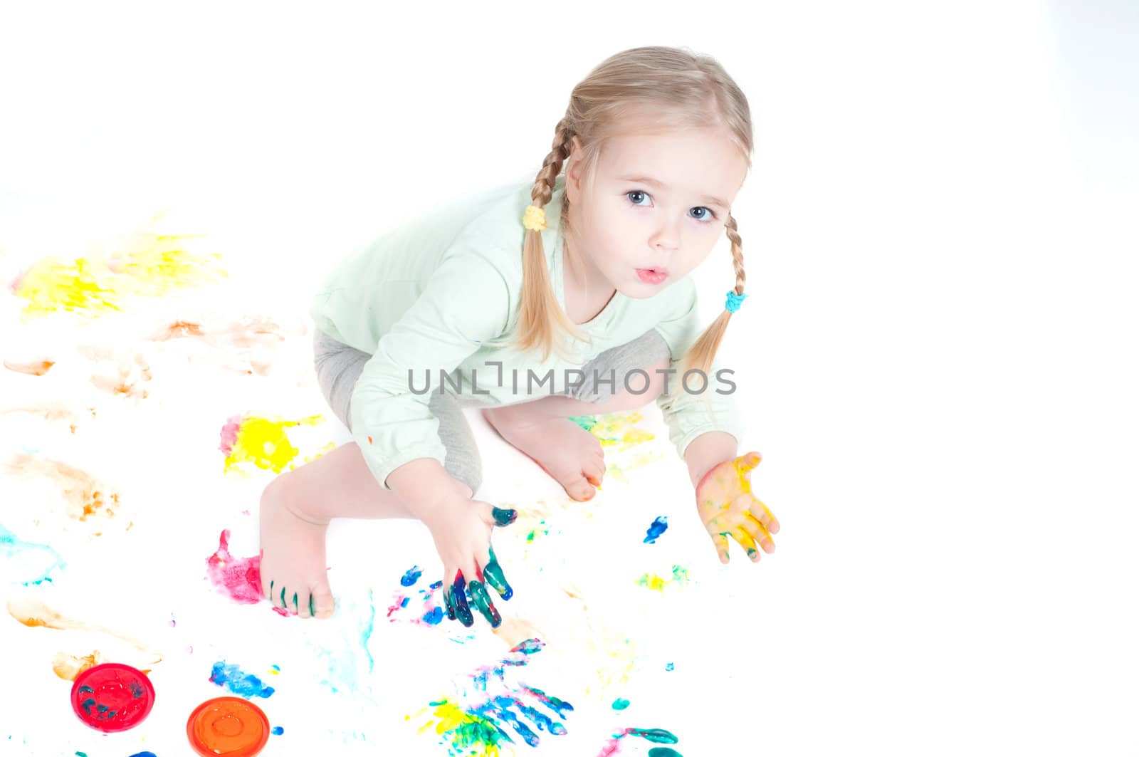 Studio shot of little girl playing with colors