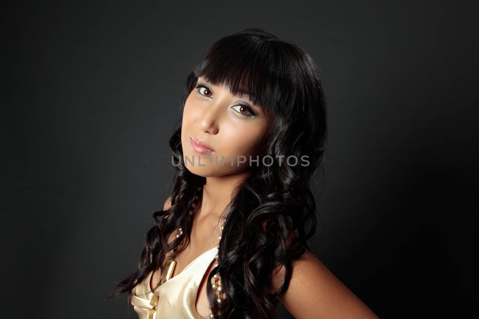 Beautiful young woman with long luscious shiny dark hair lightly curled.