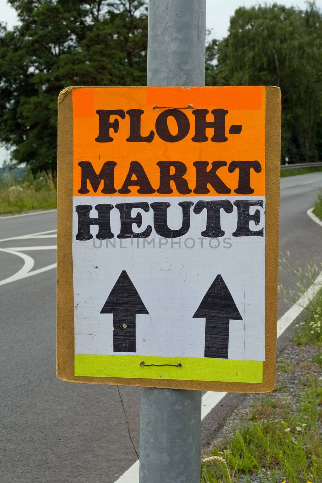 A poster on a street points the way to a flea market