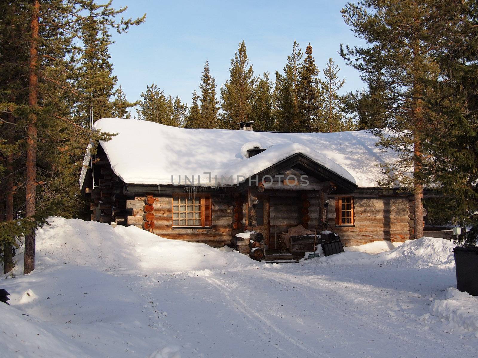 Snow-covered log cabin in a holiday resort in Yllas, Lapland, Finland.