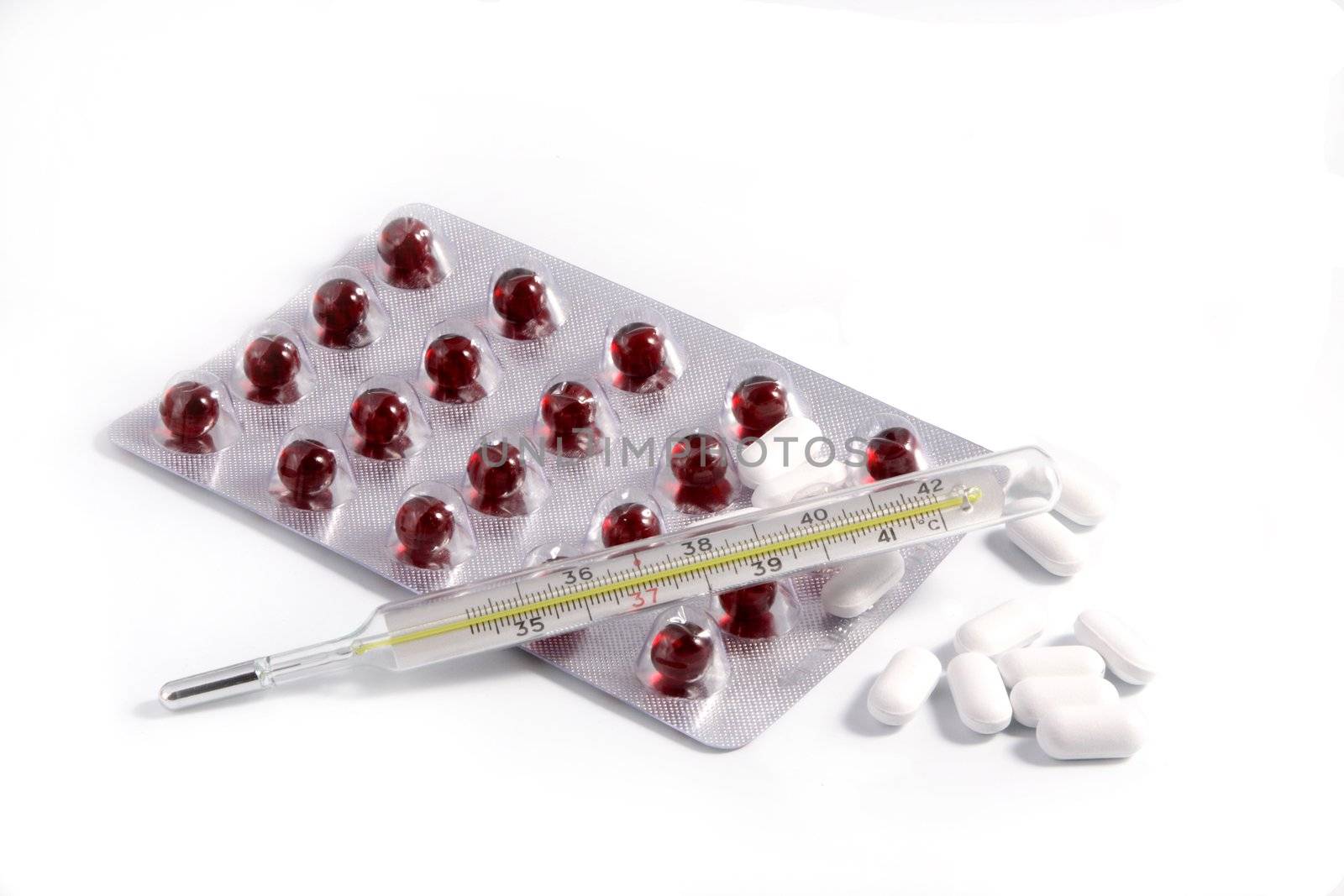 Thermometer, tablets in packing, a syringe on a white background.