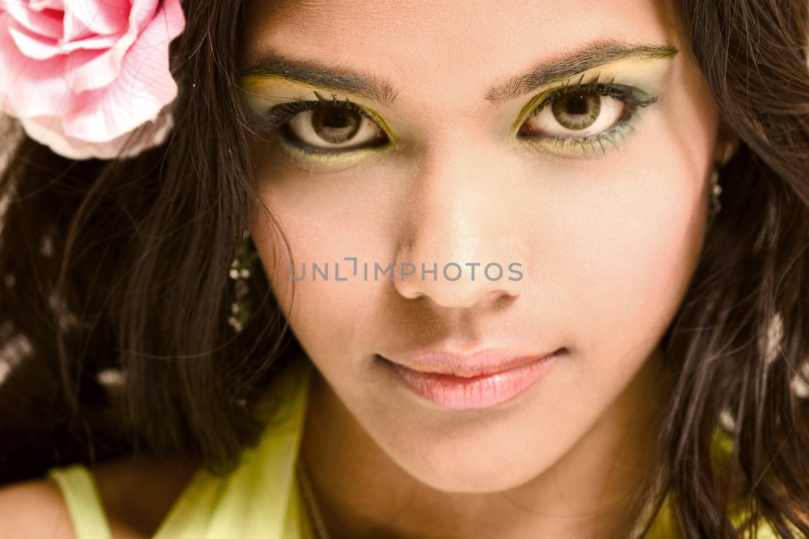 Studio portrait of an Indian  Indonesian beauty model with a rosa rose in her hair