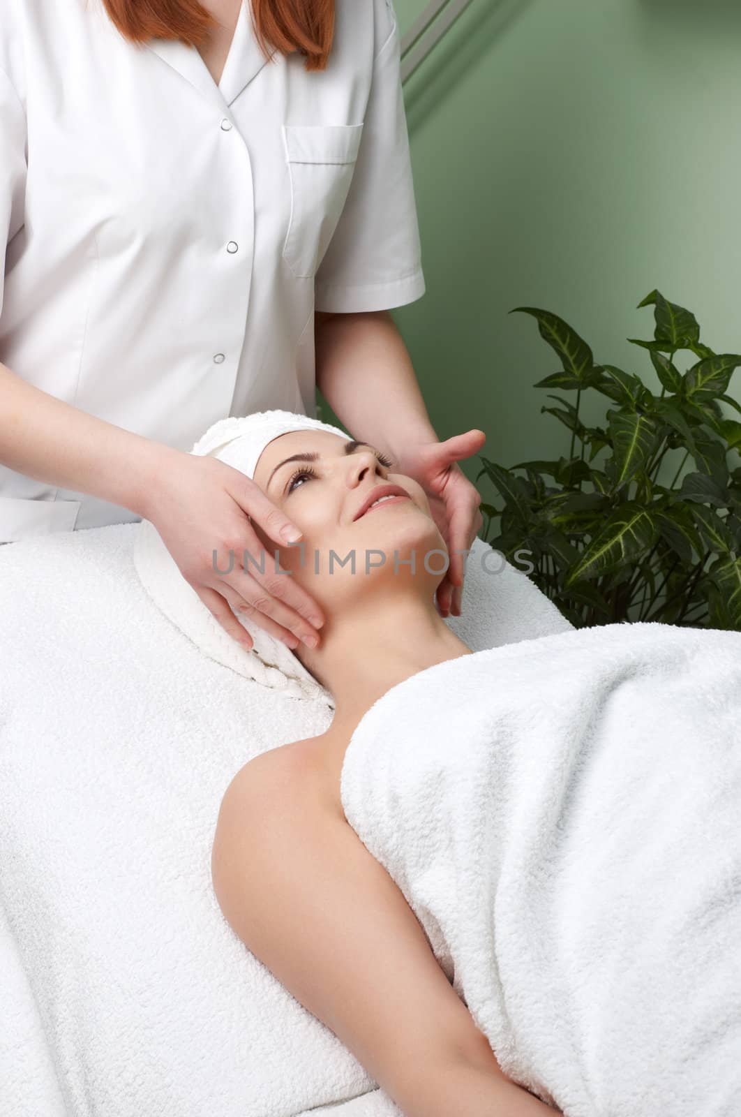 pretty woman getting facial massage in the beauty salon