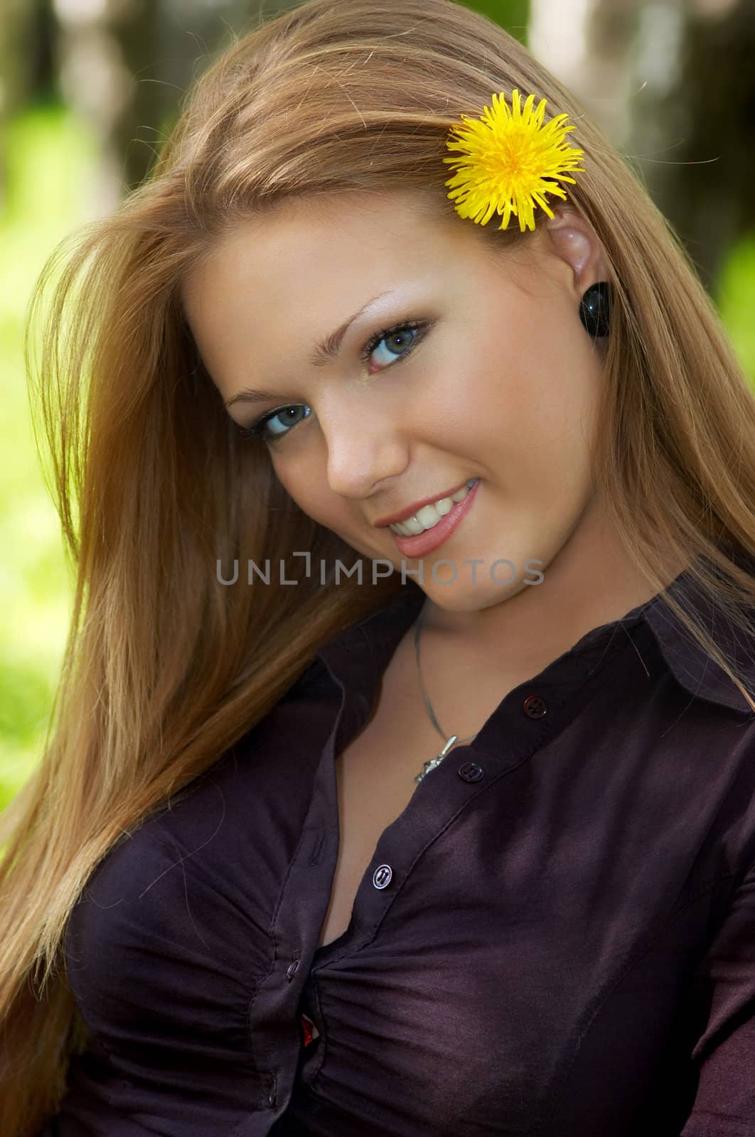 outdoor portrait of gorgeous girl with dandelion in her hair