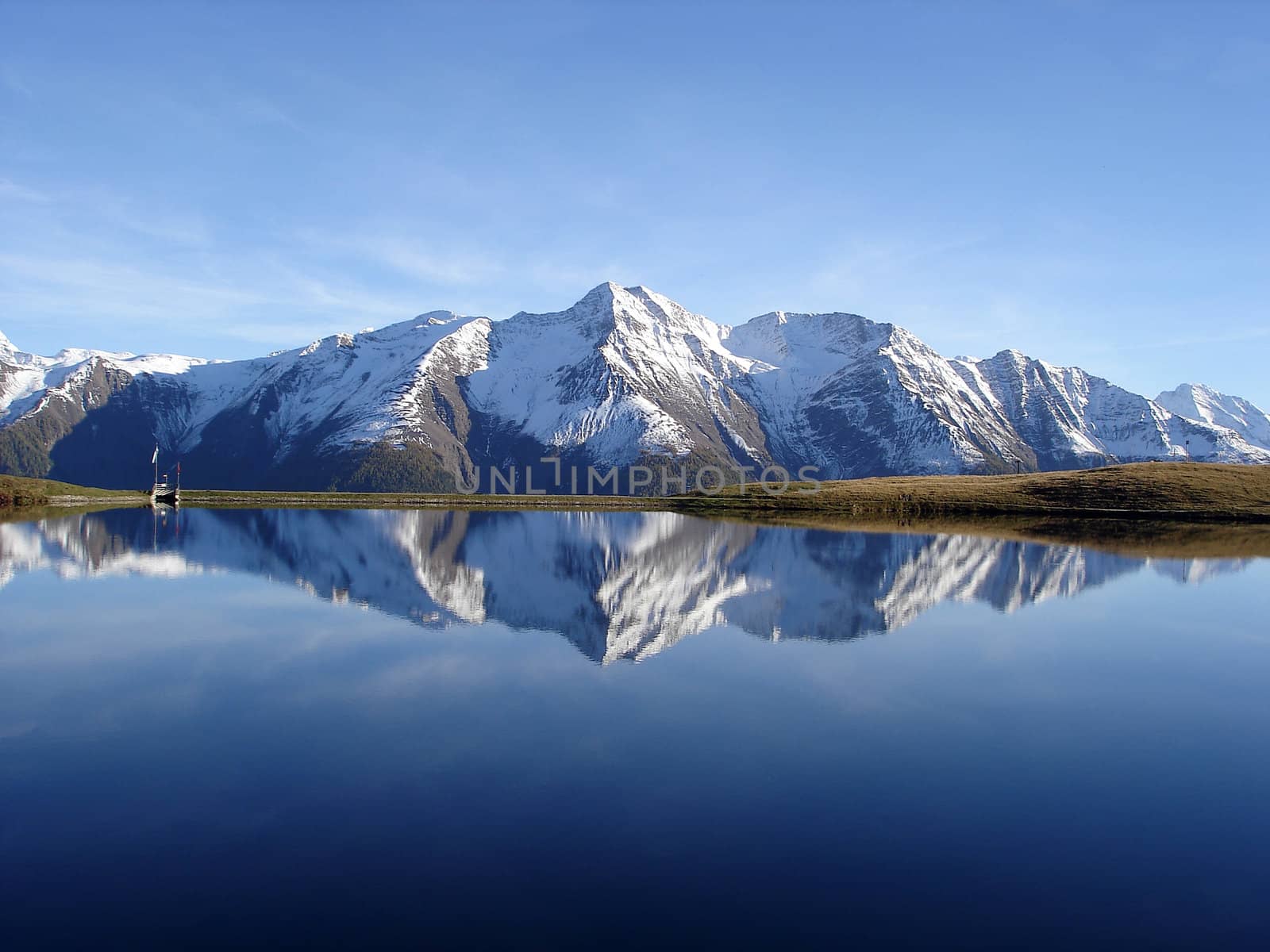 Snowcapped Mountain Reflection In The Water Of Bettmersee Lake Aletsch Region Valais Canton.