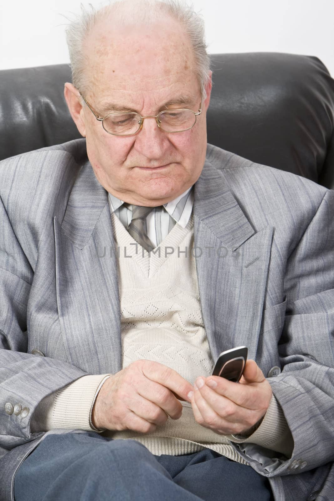 Close-up image of a senior man typing a message on his mobile phone.
