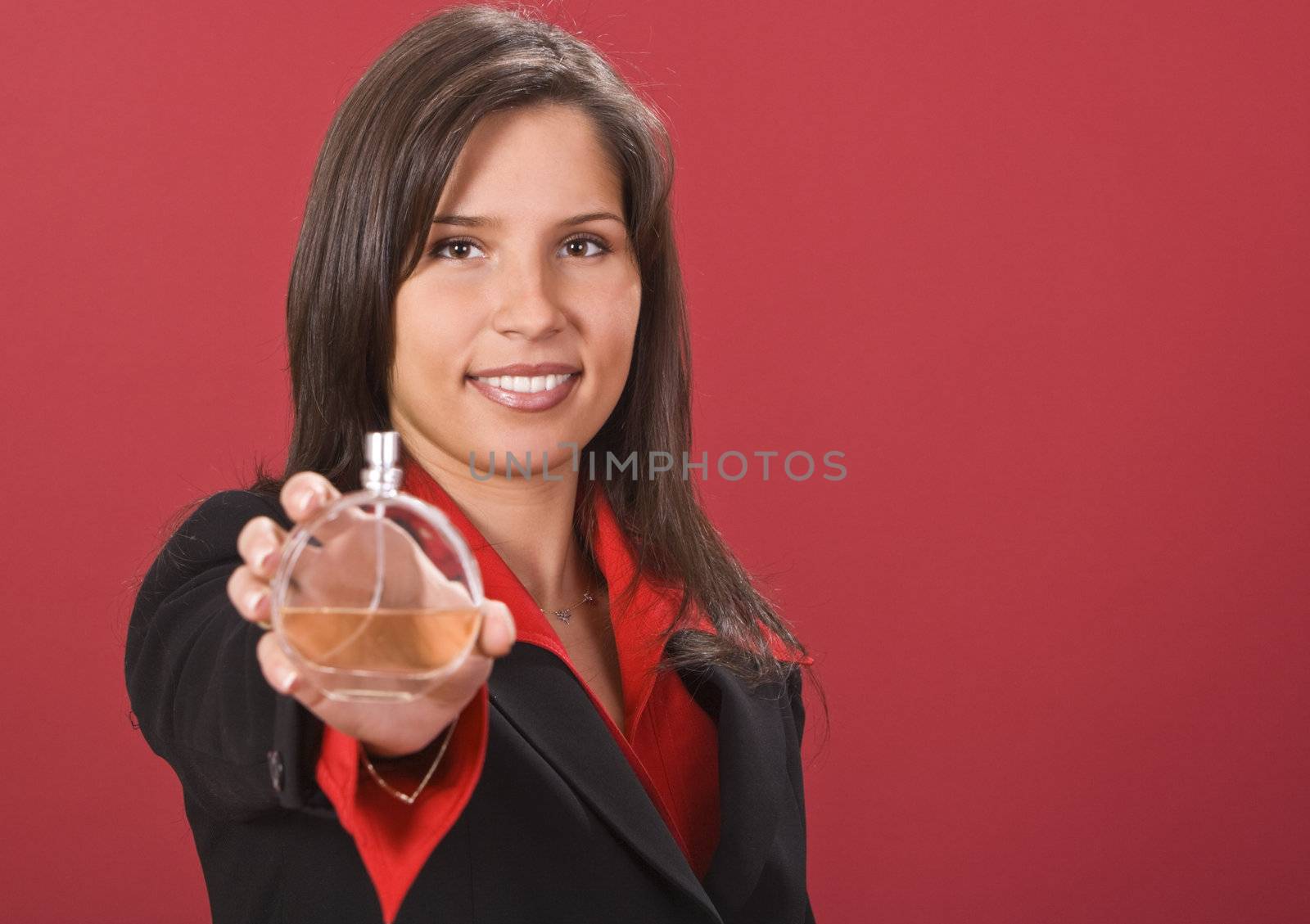 Young beautiful woman (seller) offering a bottle of perfume.