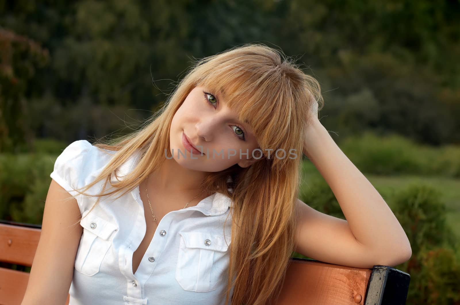 young female sitting on the bench in the park