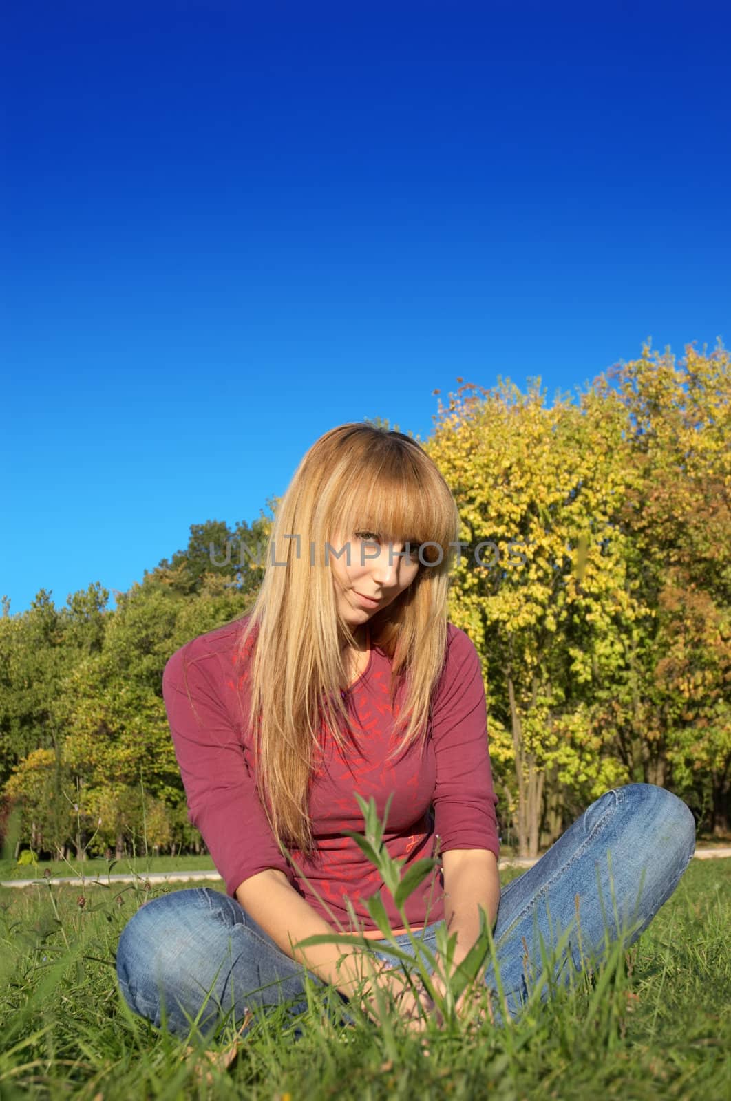 slim shaped beautiful blond girl relaxing at park meadow