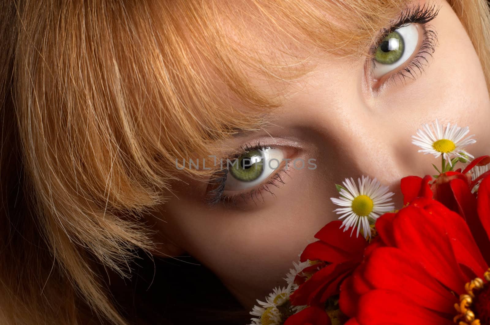 beautiful girl's green eyes and bouquette of red flowers.