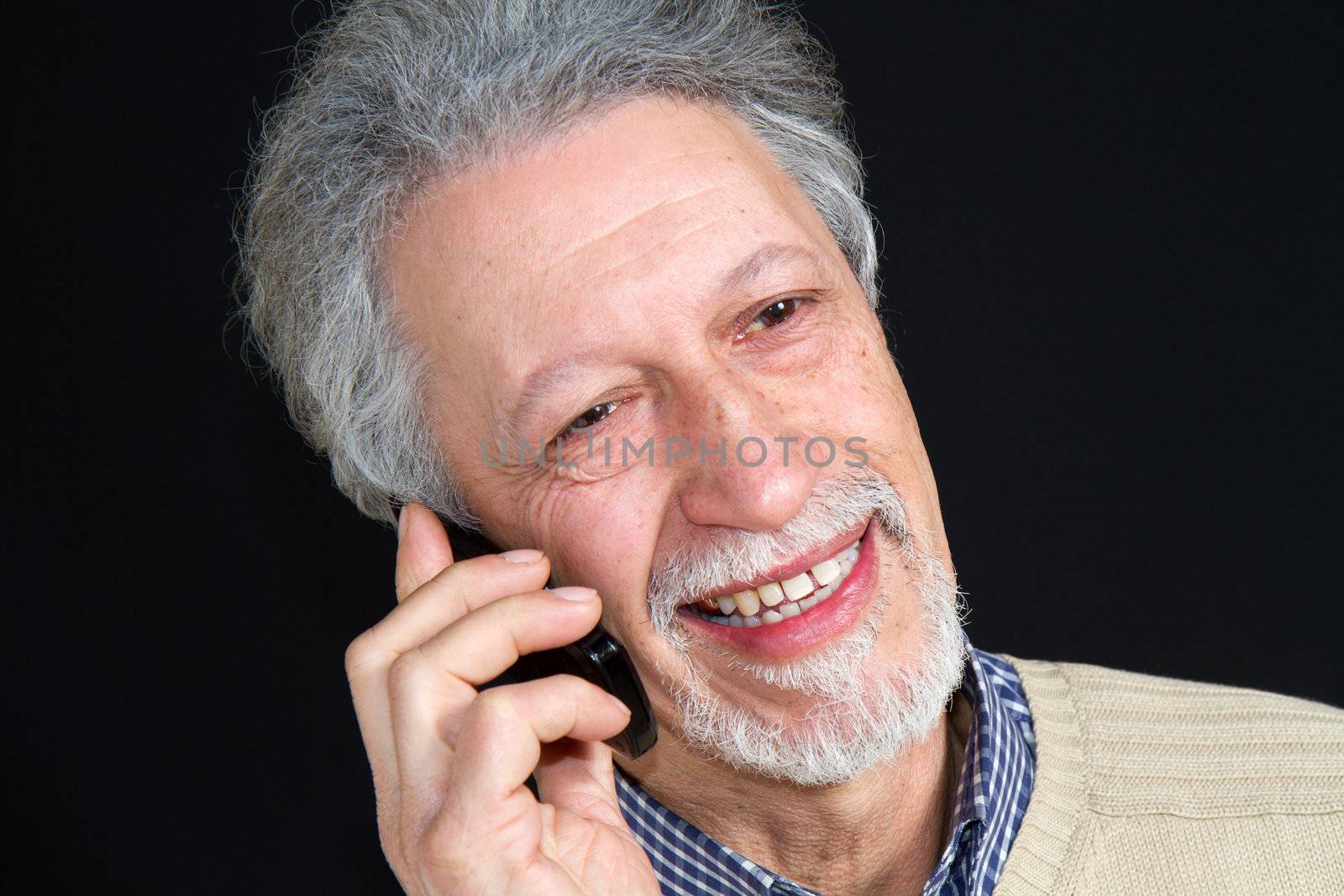 mature man talking on his mobile phone isolated on black background