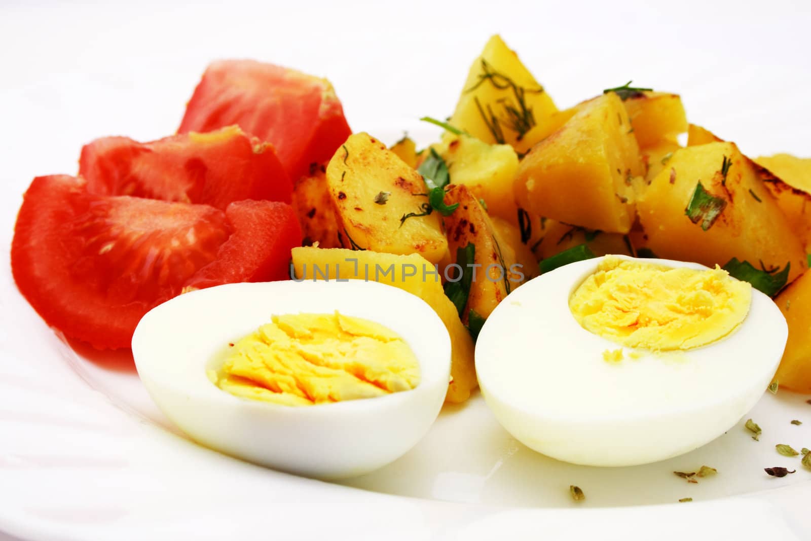 Zoomed foto of tomatoes, fried potatoes and eggs