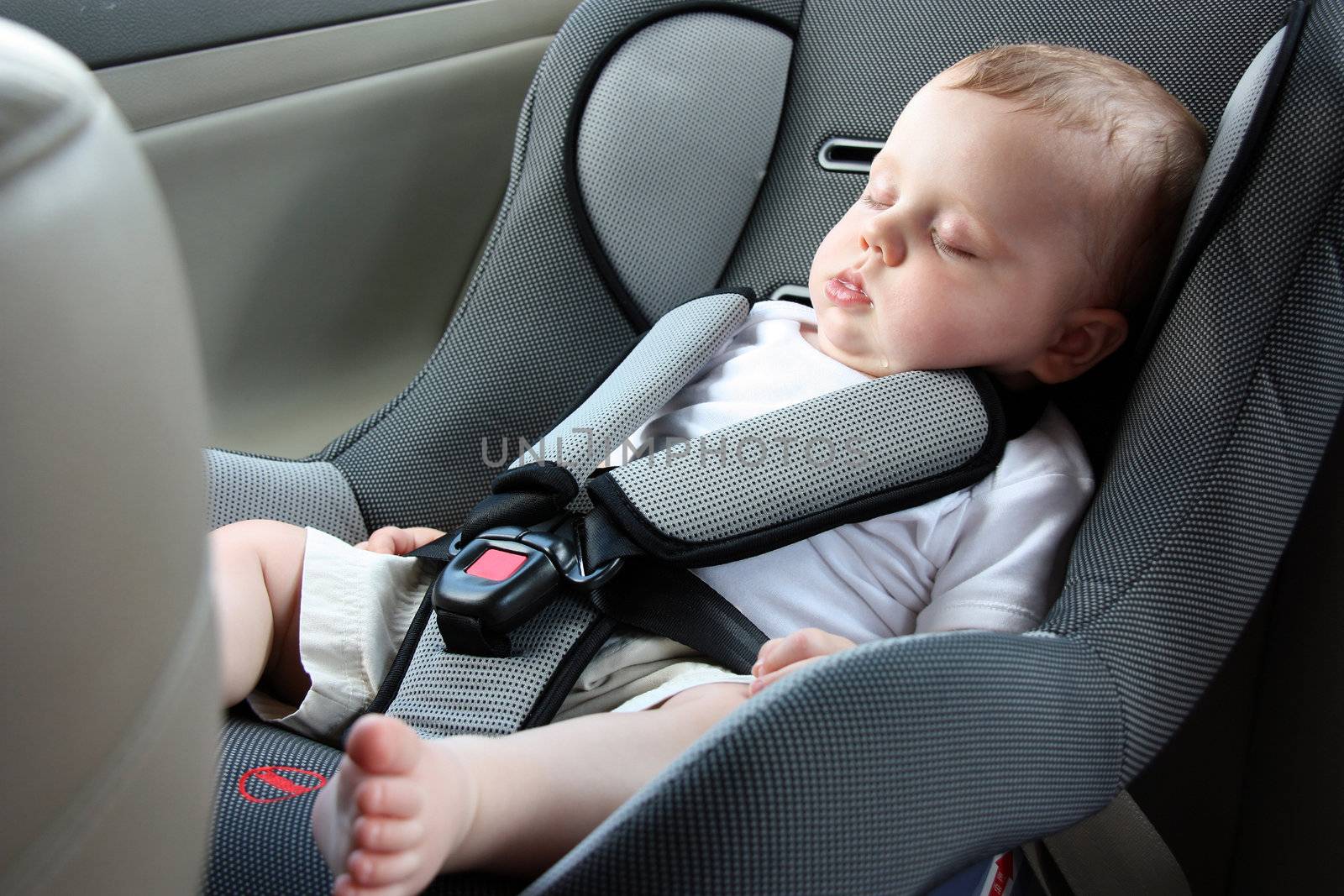 little baby sleeping peacefully in the car seat