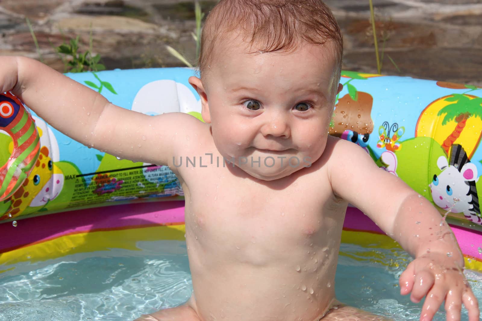 funny gay kid happily splashing in the small pool