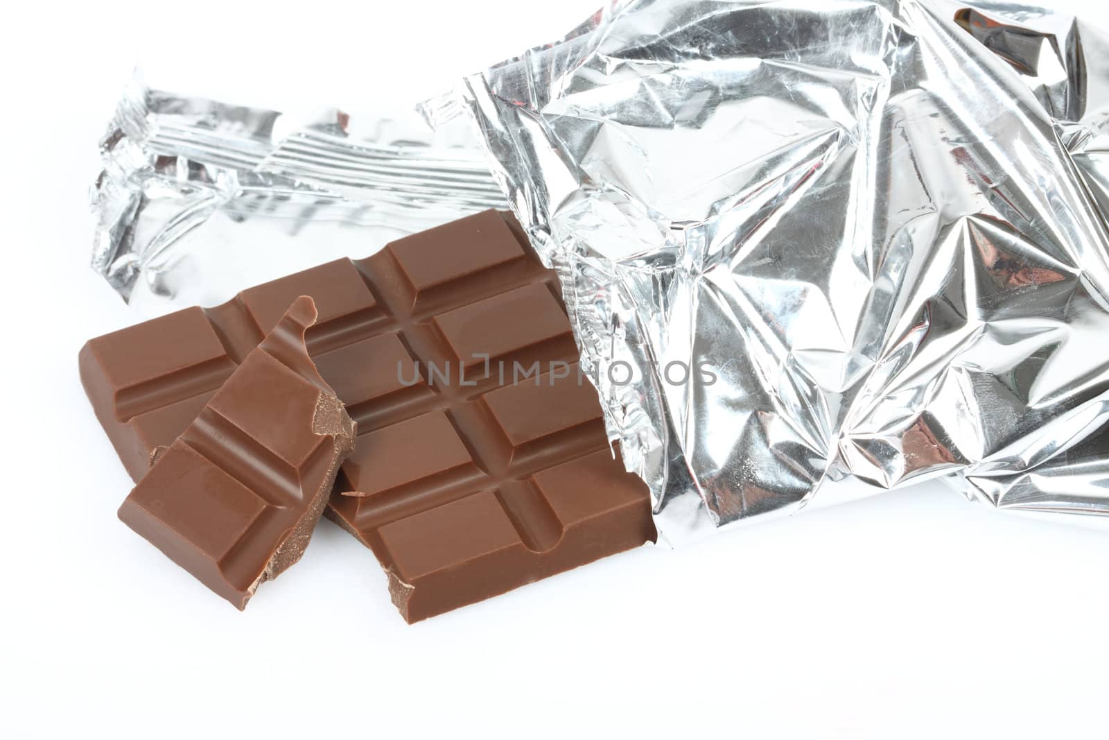 Chocolate bar in foil close up over white 