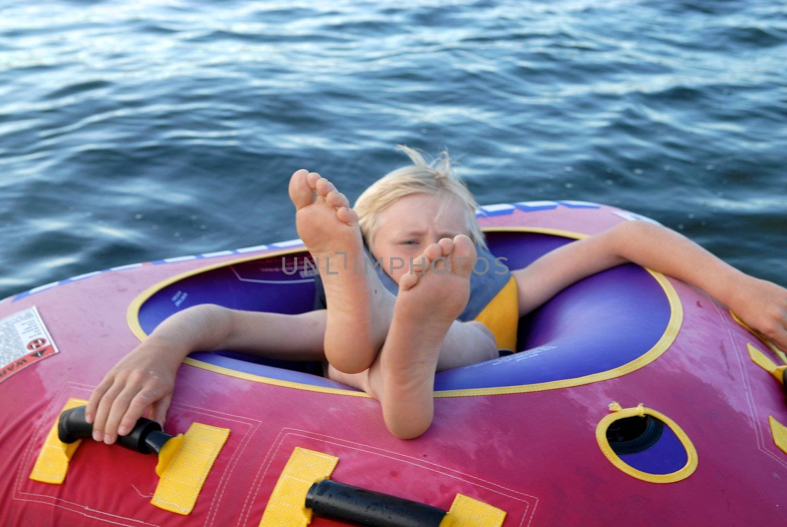 a boy lying on the rubber raft. Please note: No negative use allowed.