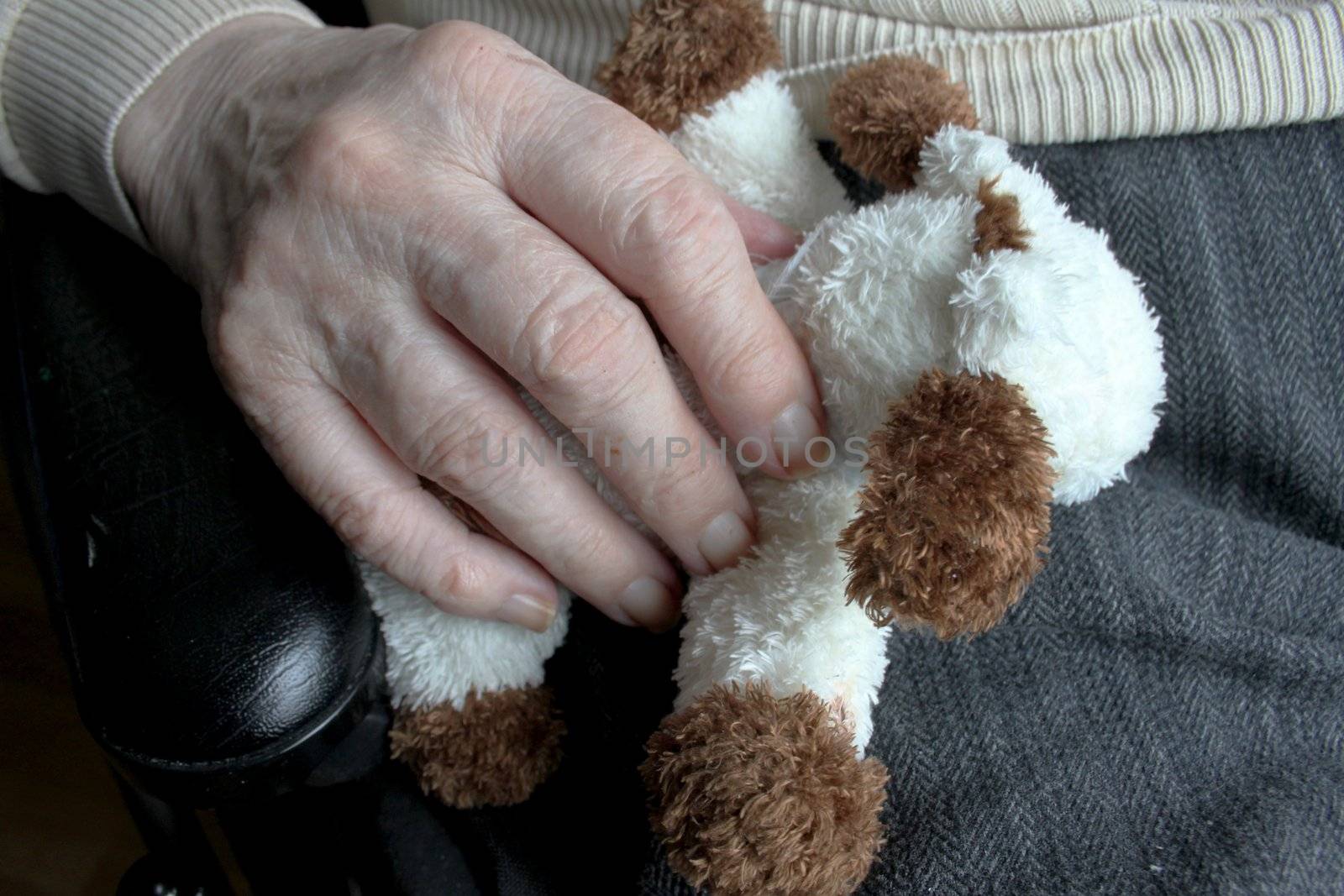 Elderly woman's hand holding a small doll