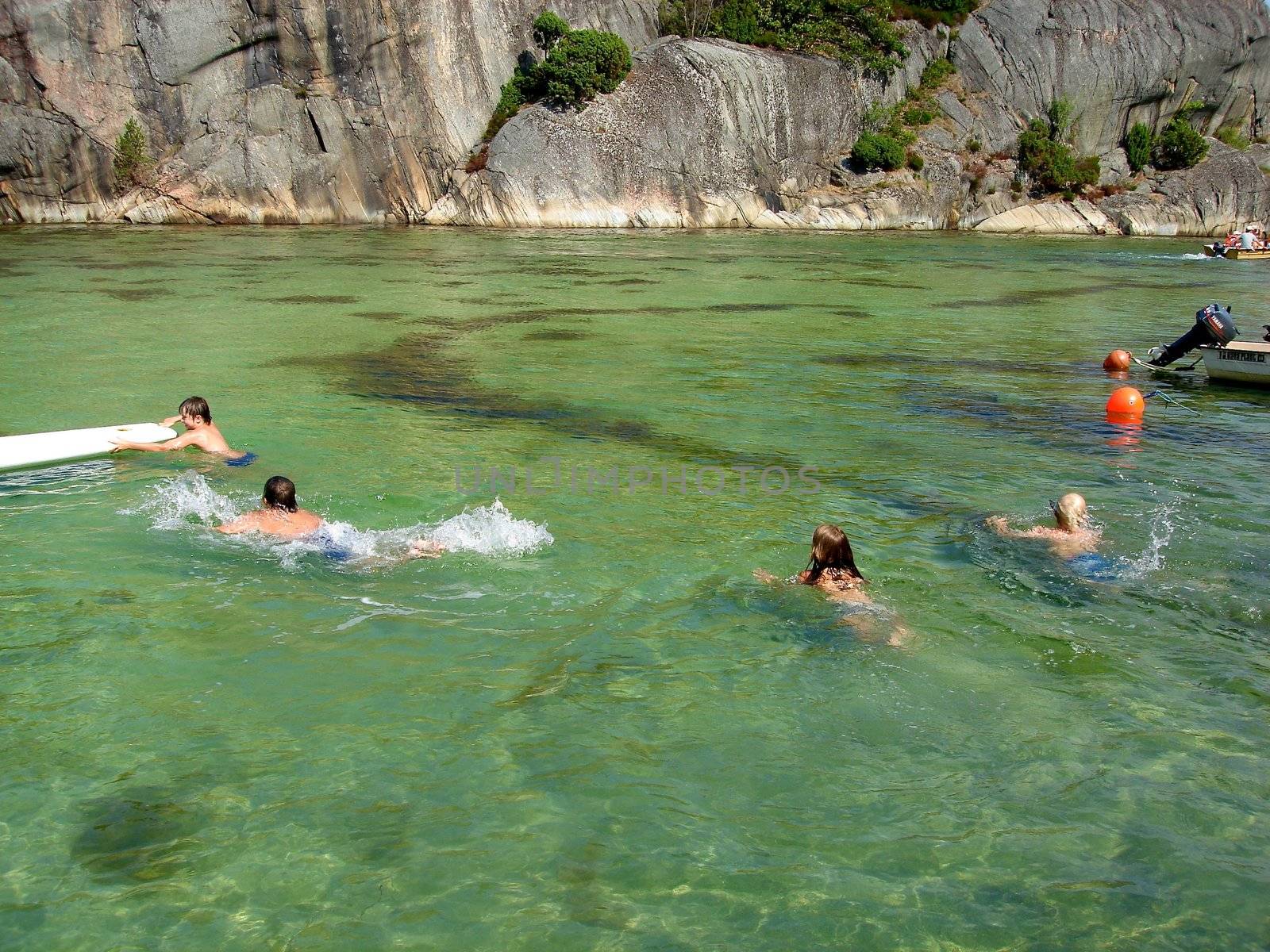 children swimming in the sea. Please note: No negative use allowed.