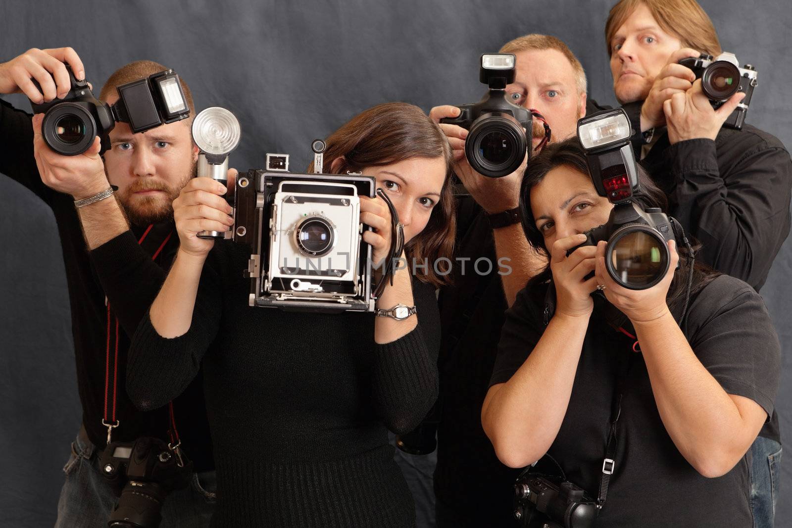 Photo of paparazzi waiting for the right moment to take photos. Focus on the two females in front.