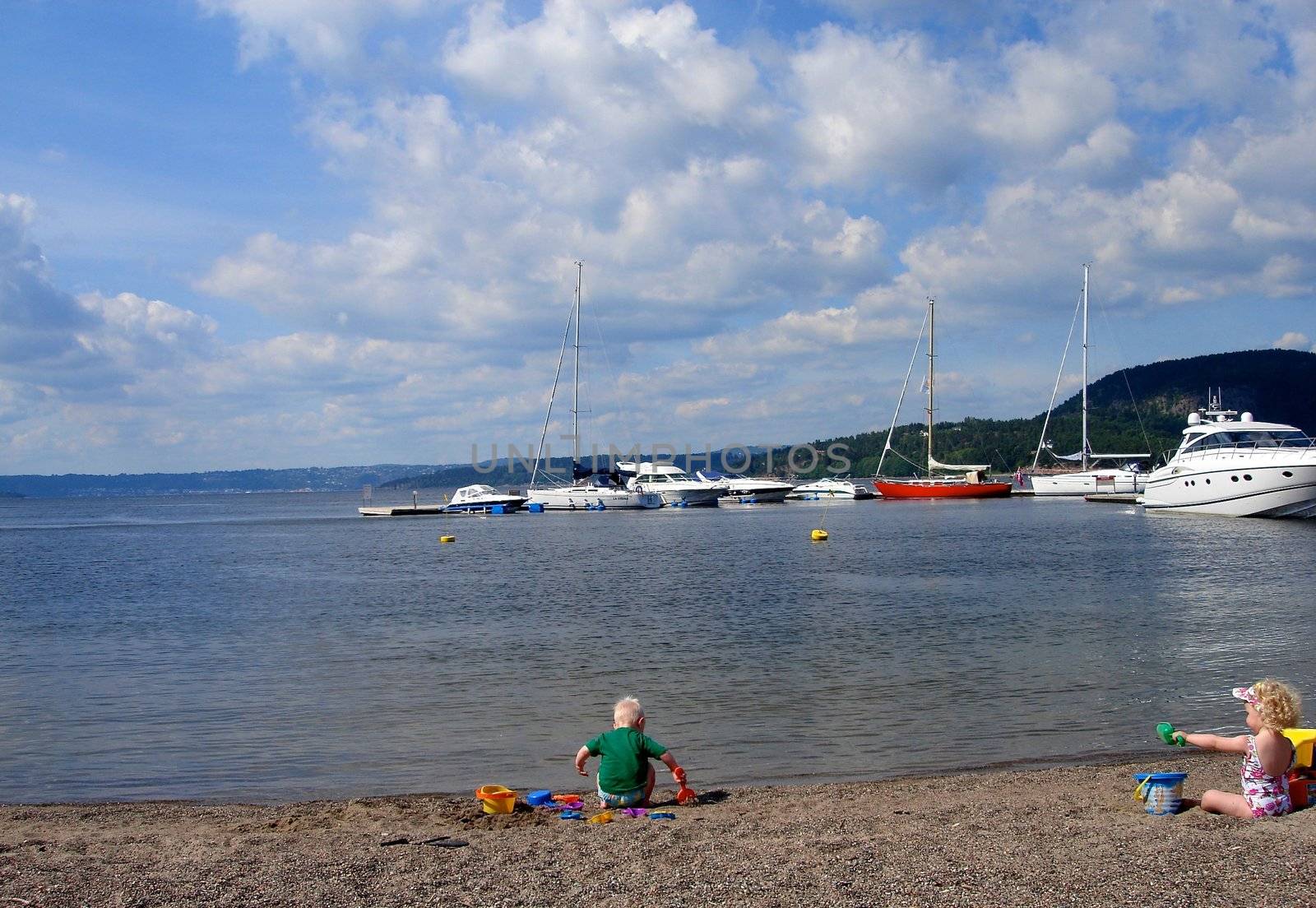 Scandinavian Lifestyle - children playing on the beach by Bildehagen