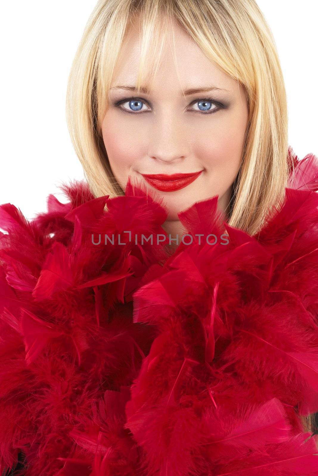 Portrait of a beautiful blonde woman with light blue eyes and dramatic make-up wrapped in red feather boa isolated on white background