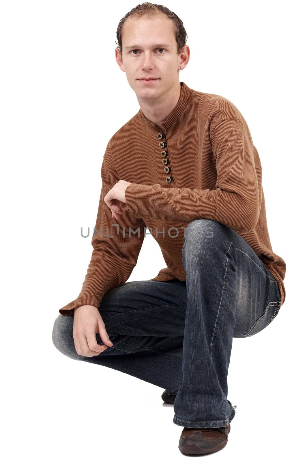 Young caucasian man wearing trendy clothes sitting down. Isolated on white background with copy space