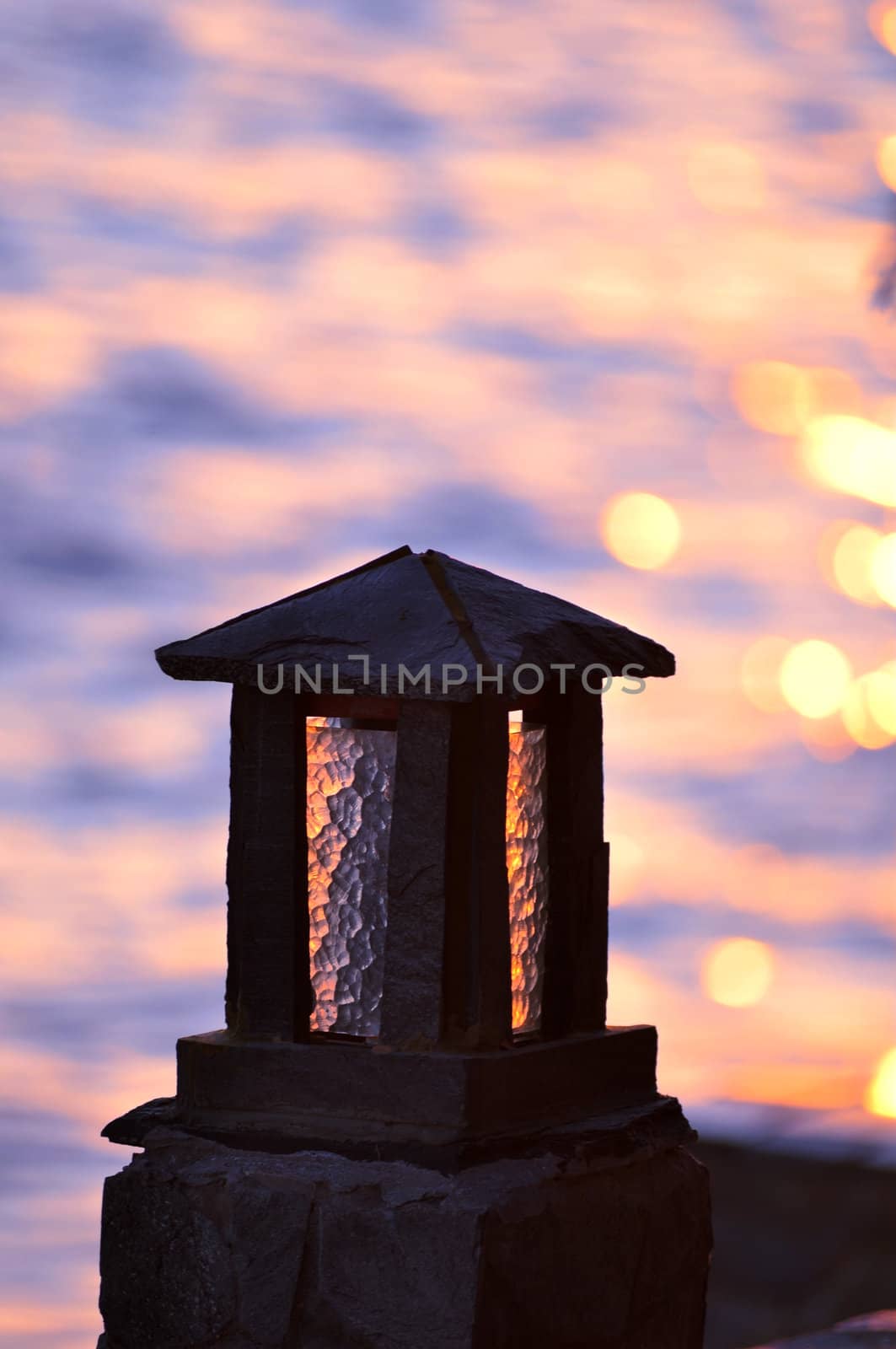 Silhouette of a stone lamp at seashore 
