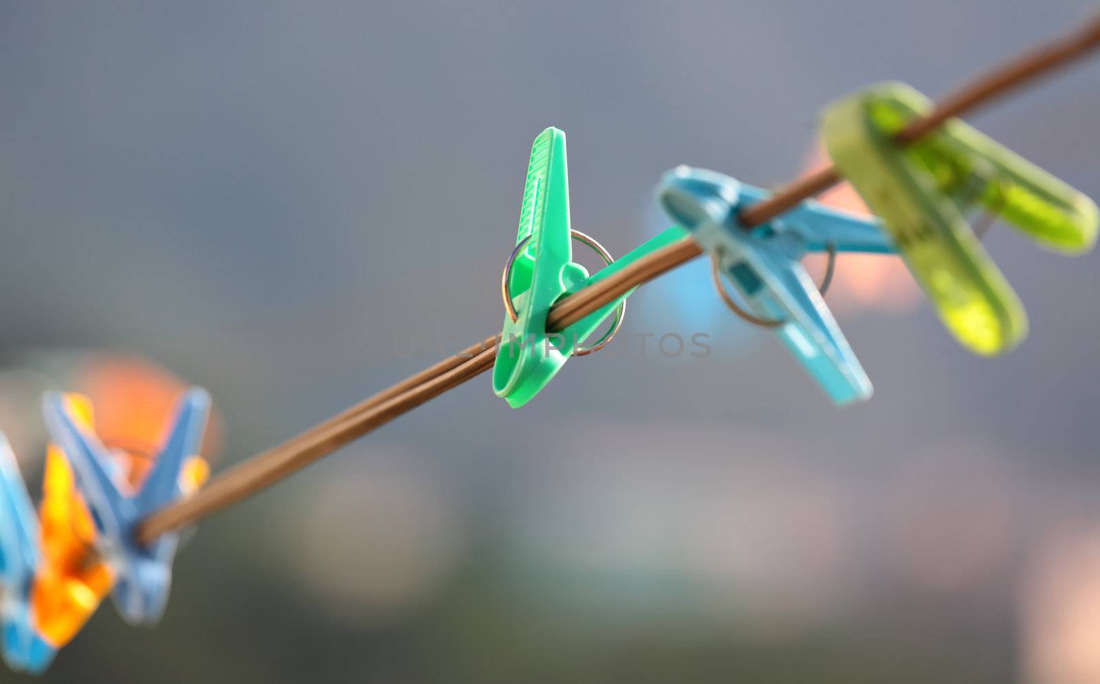 Colorful clothes pegs hanging in wire