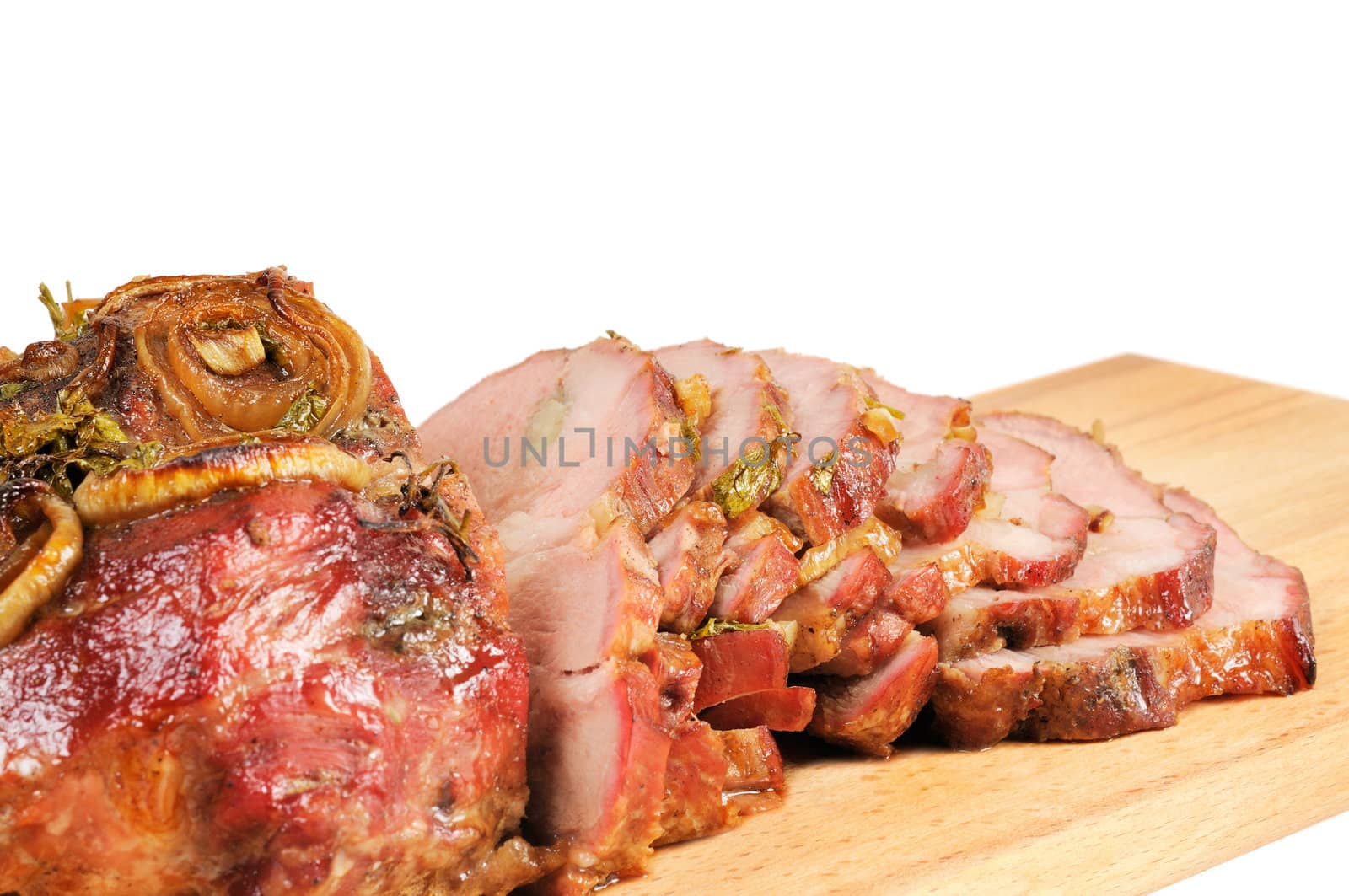 Roast pork on a wooden board. Isolated on white.