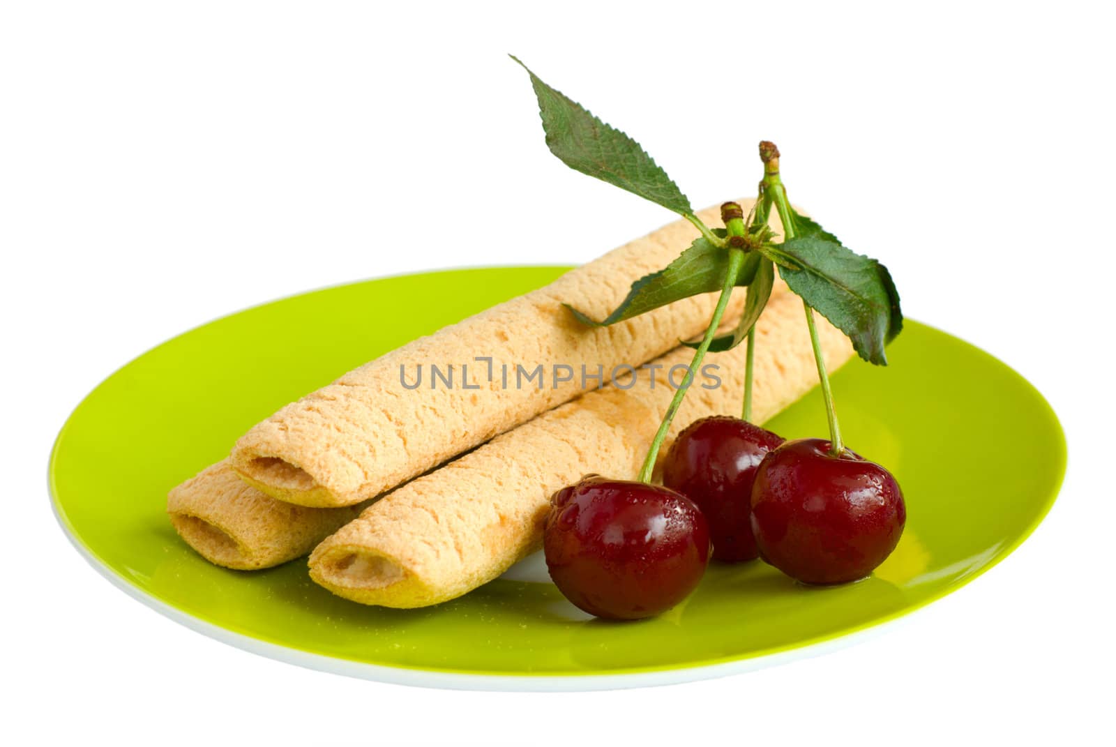 Biscuits and cherries on a green plate