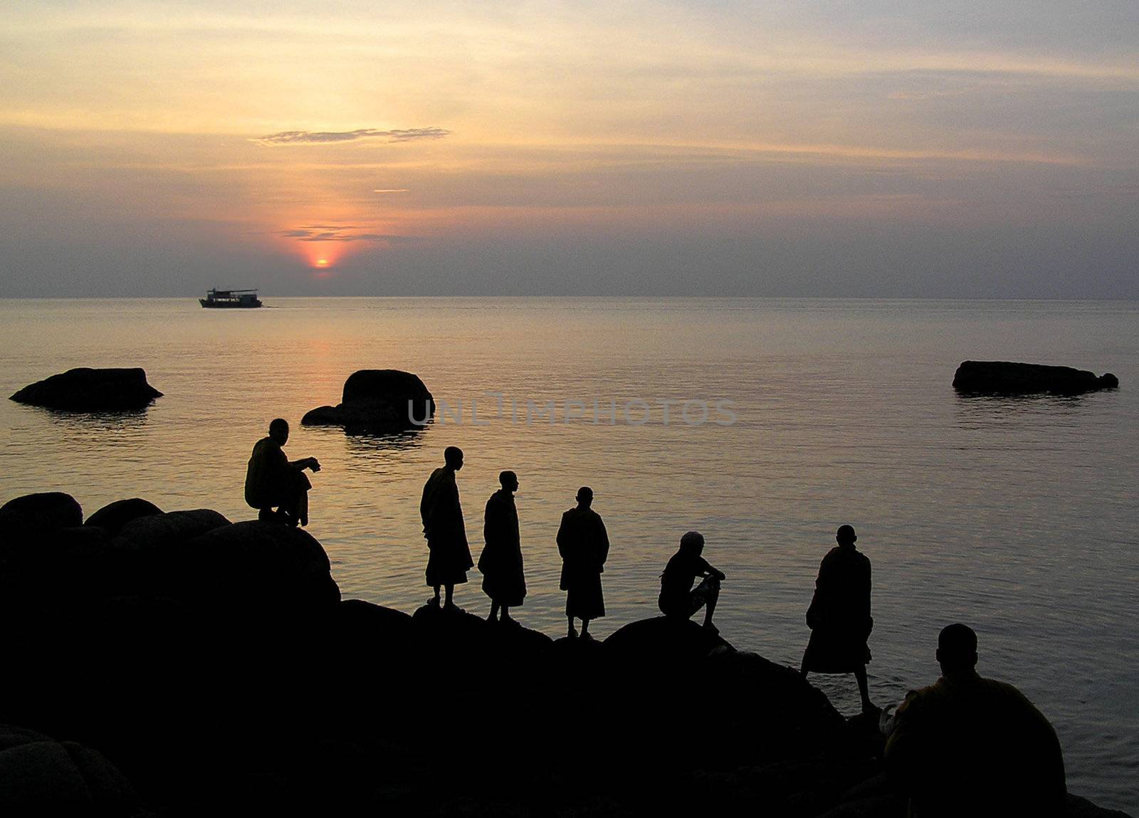 Group of monks meditating by the sea.