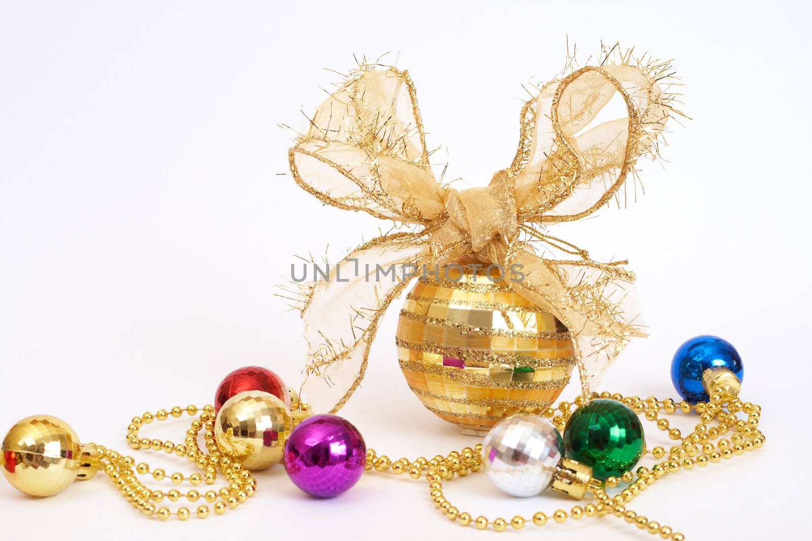 Gold Christmas bauble with colorful small balls on white background with copy space. 