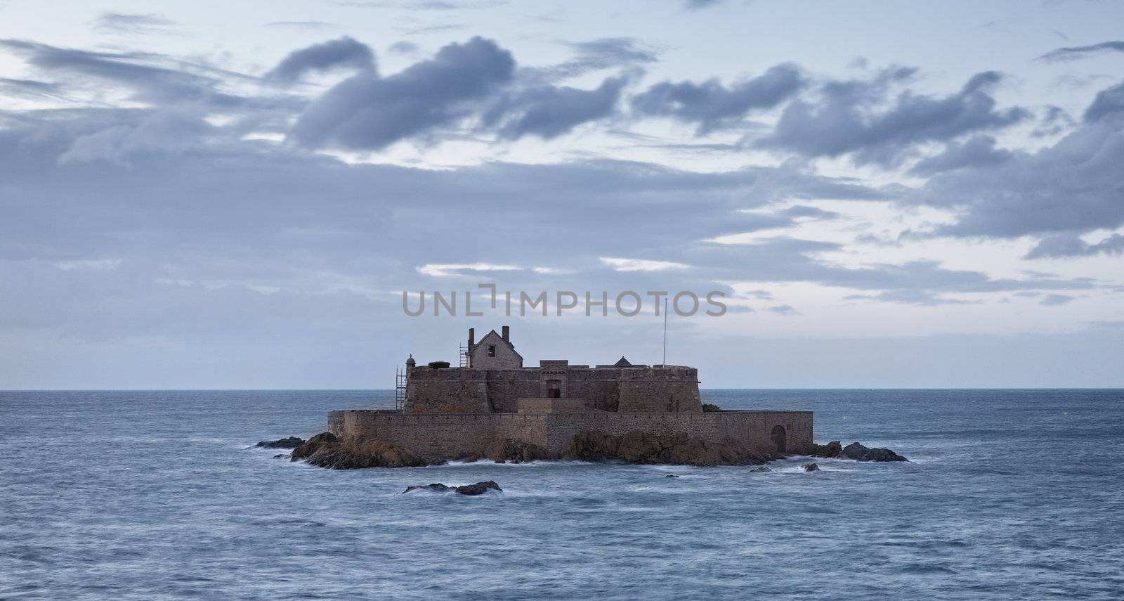 Dusk image of The Fort National from Saint Malo,in Brittany in northwestern France, during the high tide time.The construction was used first as a reference point for the ships and from 1869 became a defensive bastion against the English attacks.