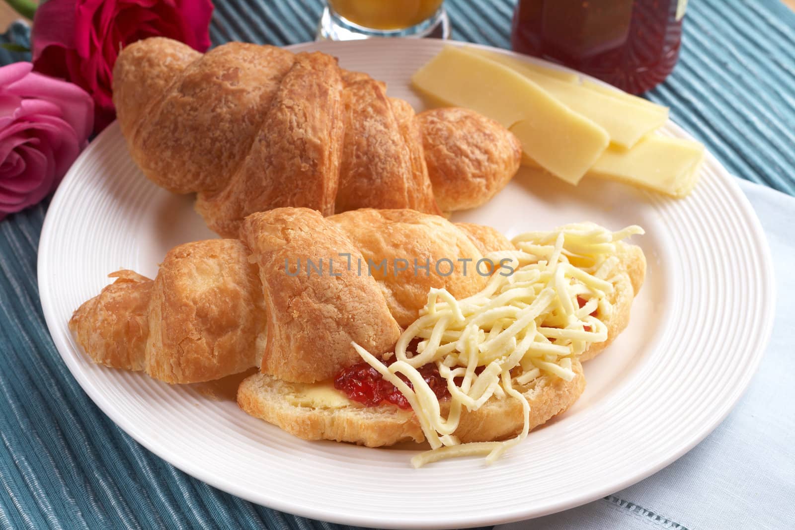 Breakfast plate with freshly baked croissants filled with jam and grated mozzarella cheese