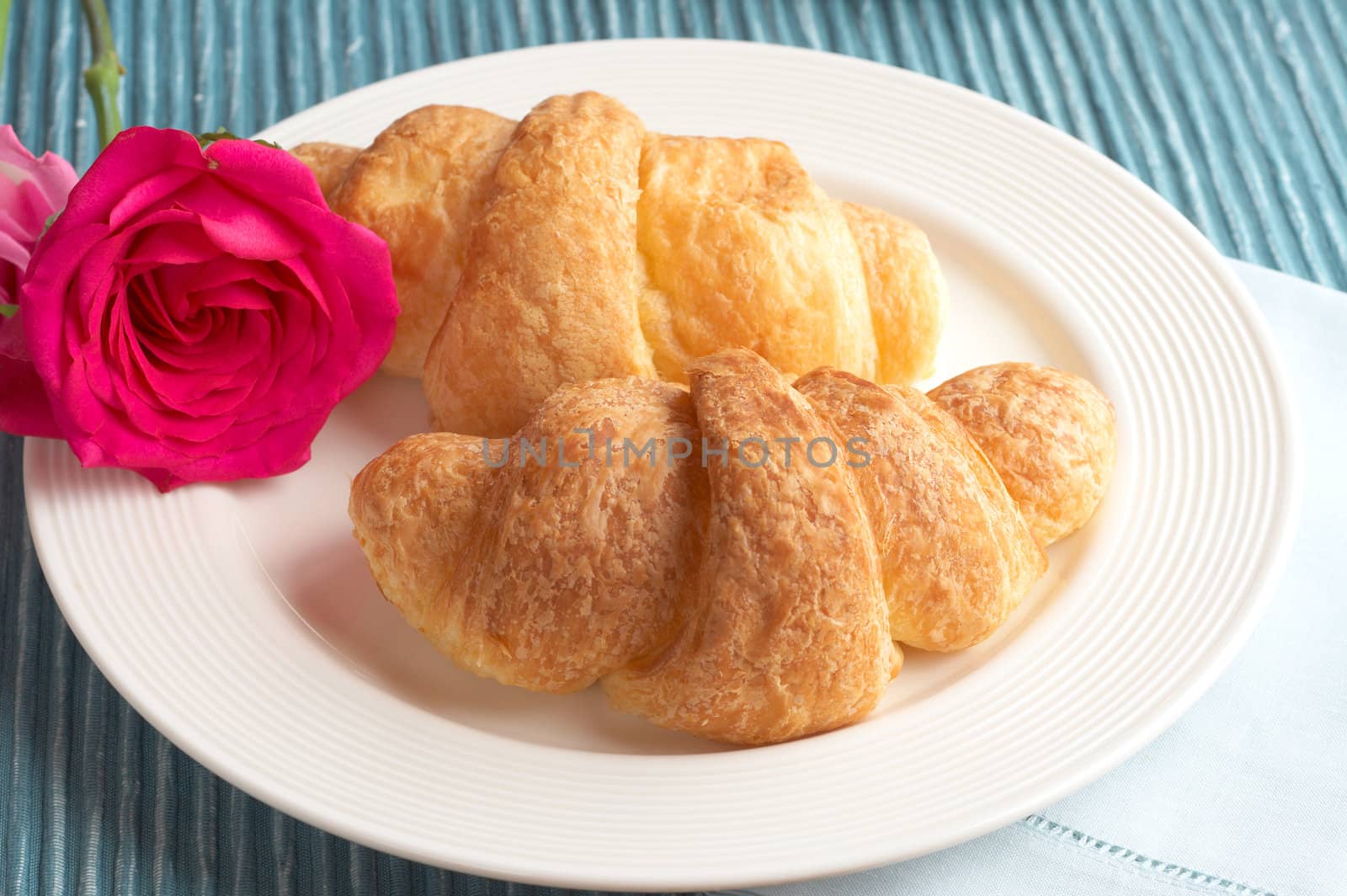 Breakfast plate with freshly baked croissants with roses