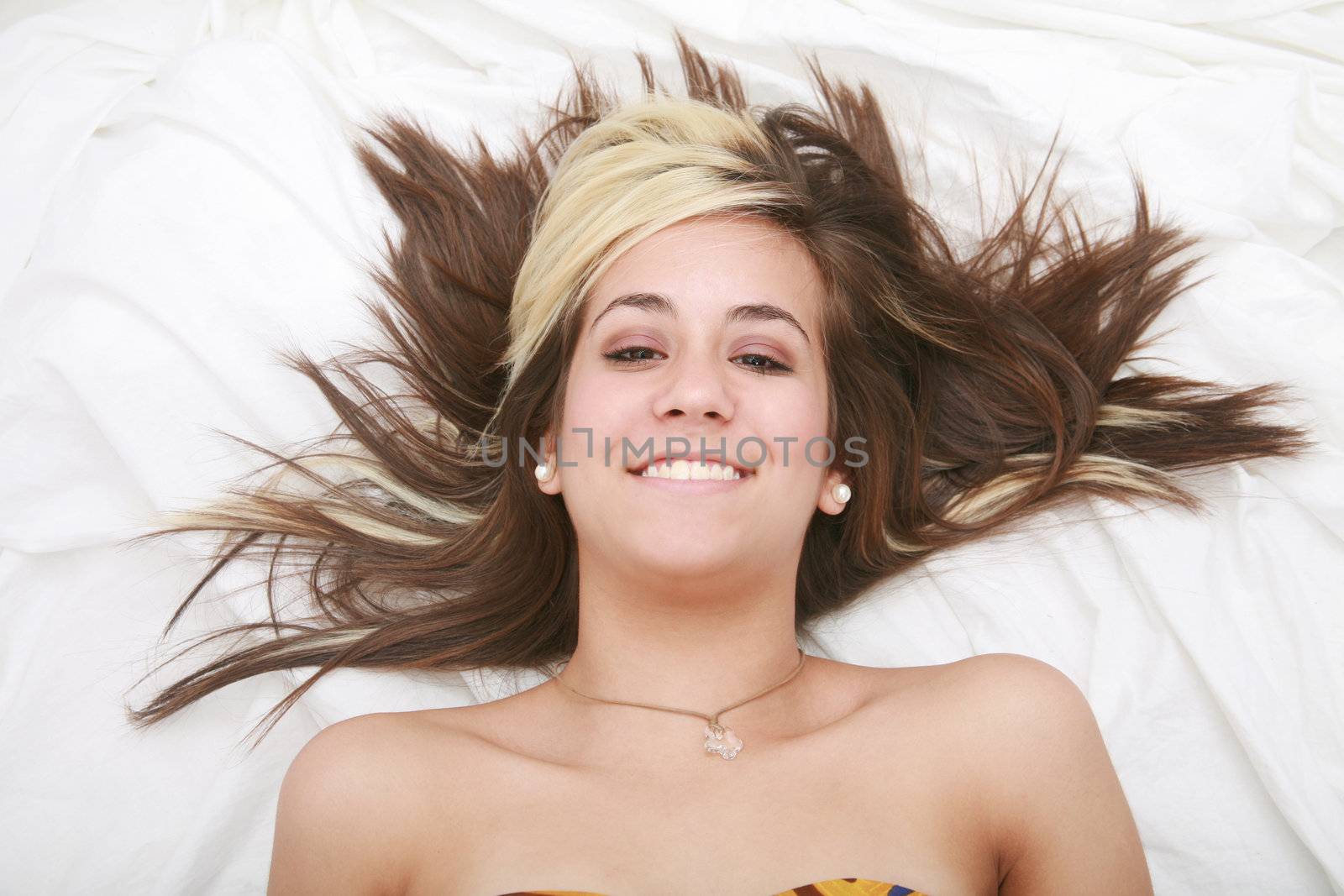 Woman lying in bed smiling by dacasdo