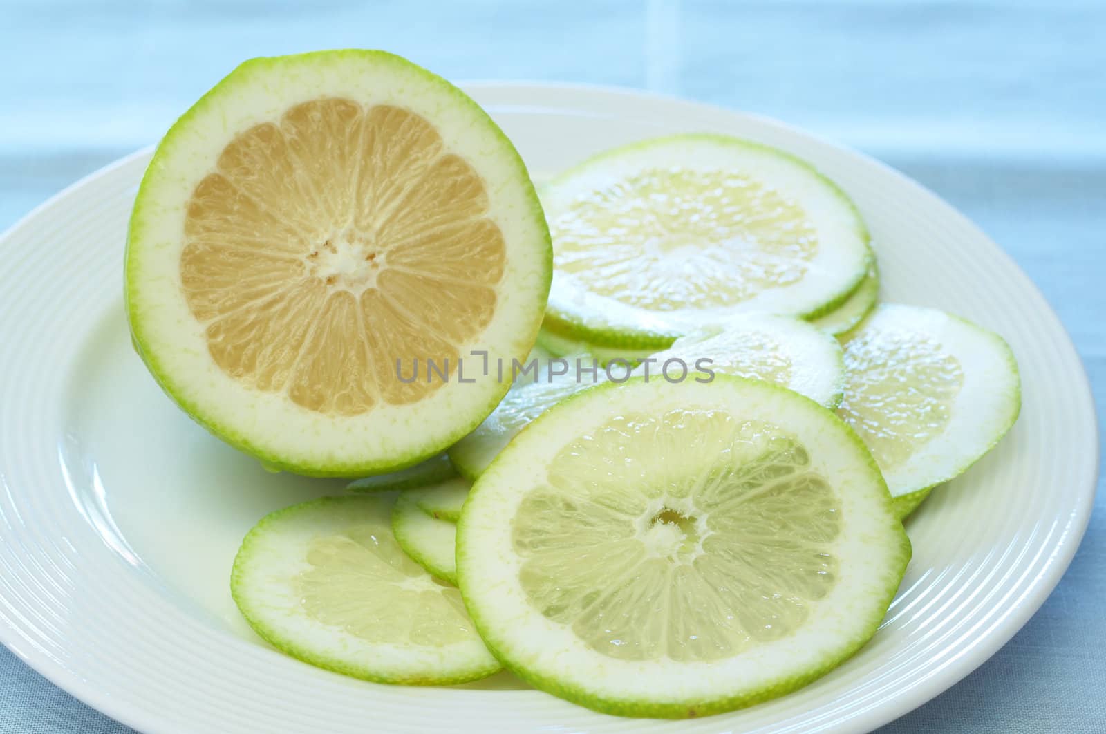 Closeup of lime lemons on a white plate. Focus on the slice.