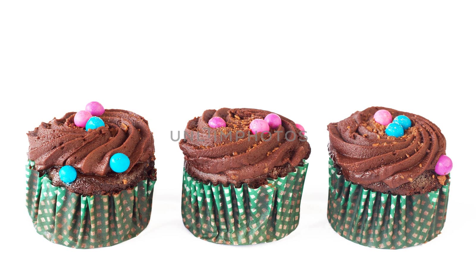 Miniature decorated chocolate cupcakes isolated on white background