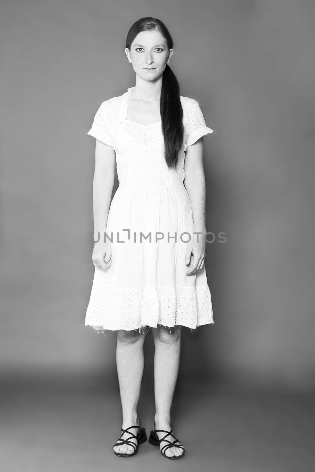 Studio portrait of a classic simple girl in a white dress