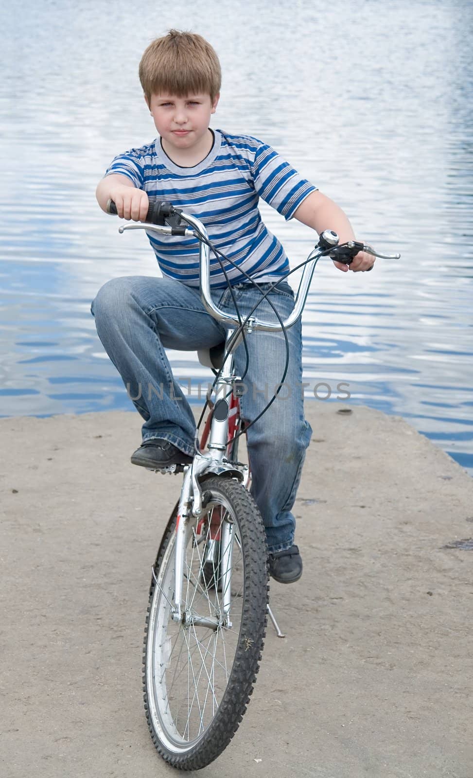 Boy on a bicycle with river at background