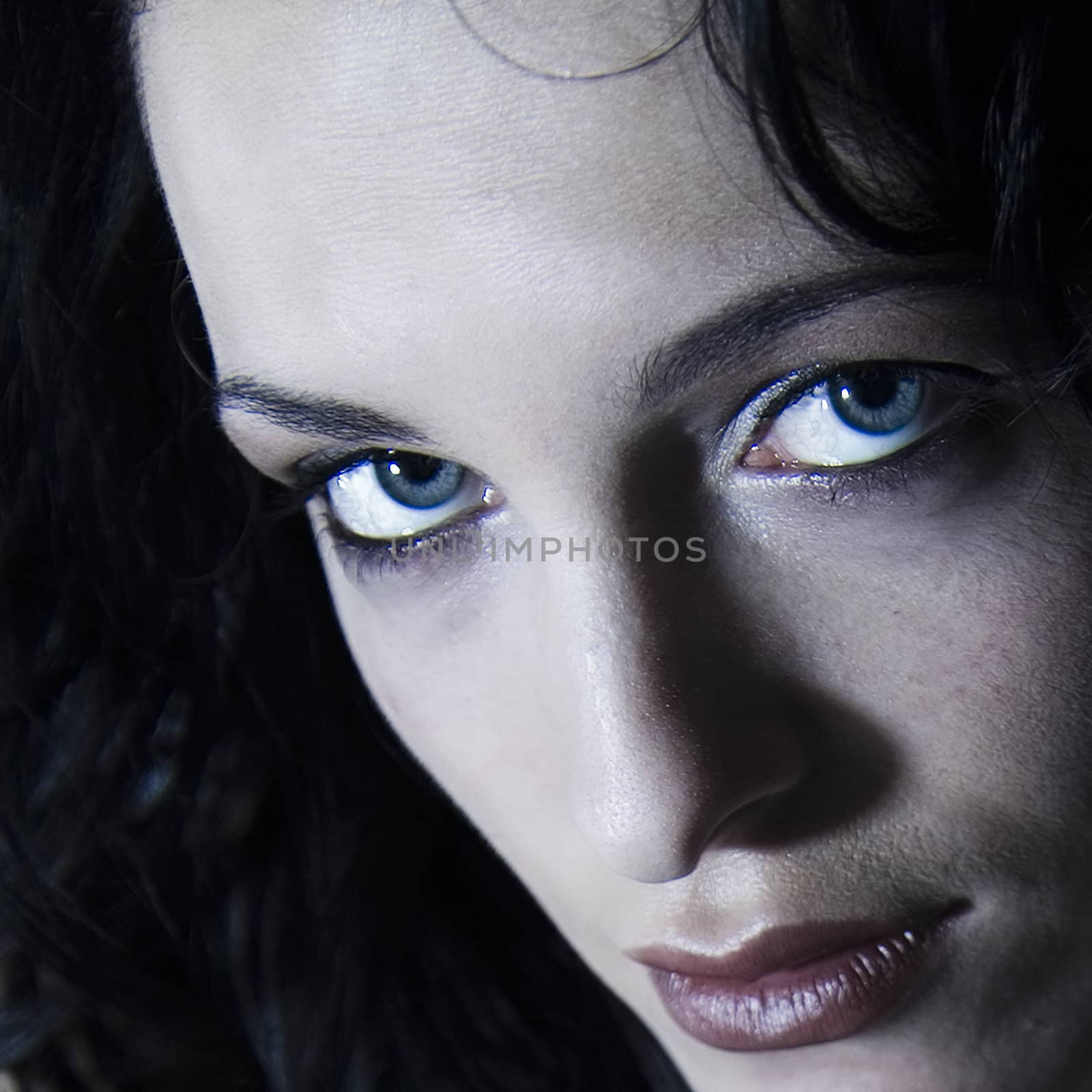 Close studio portrait of a long haired beautifull woman looking concentrated