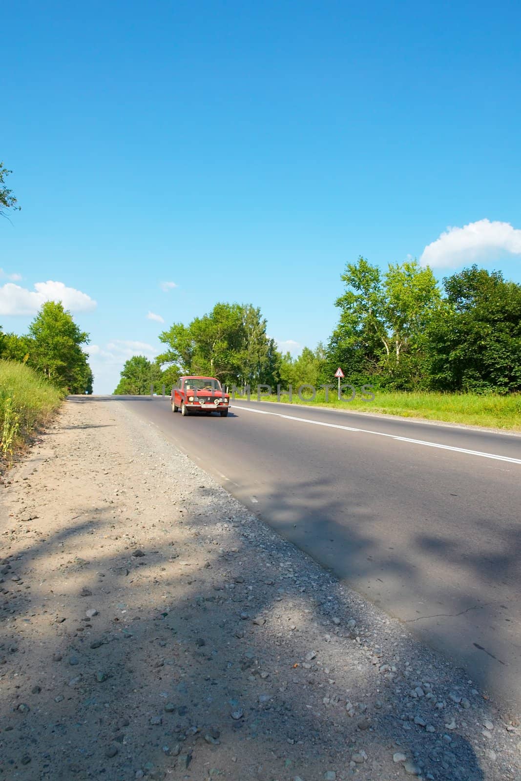 The old car moves on summer road