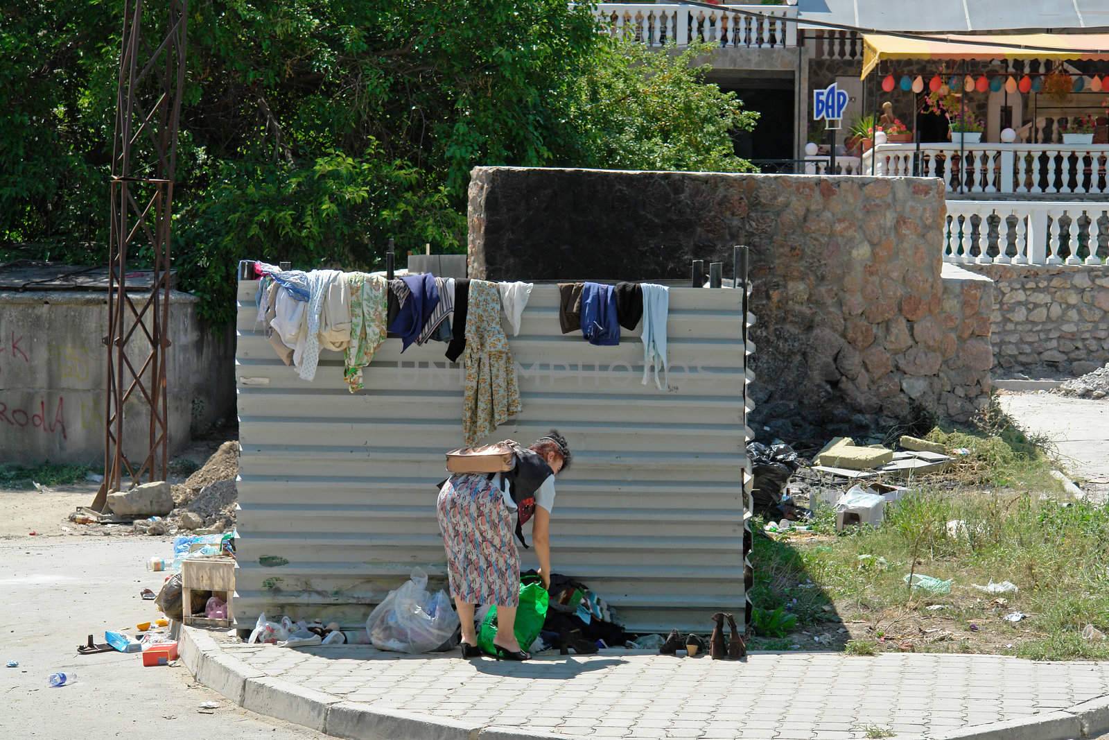 The woman rummages in a garbage heap                               