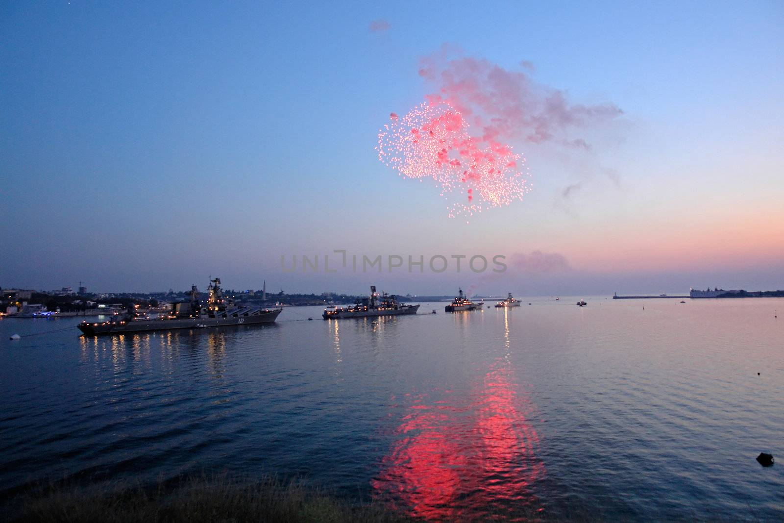 Salute on a background of the night sky, the sea and the ships                               