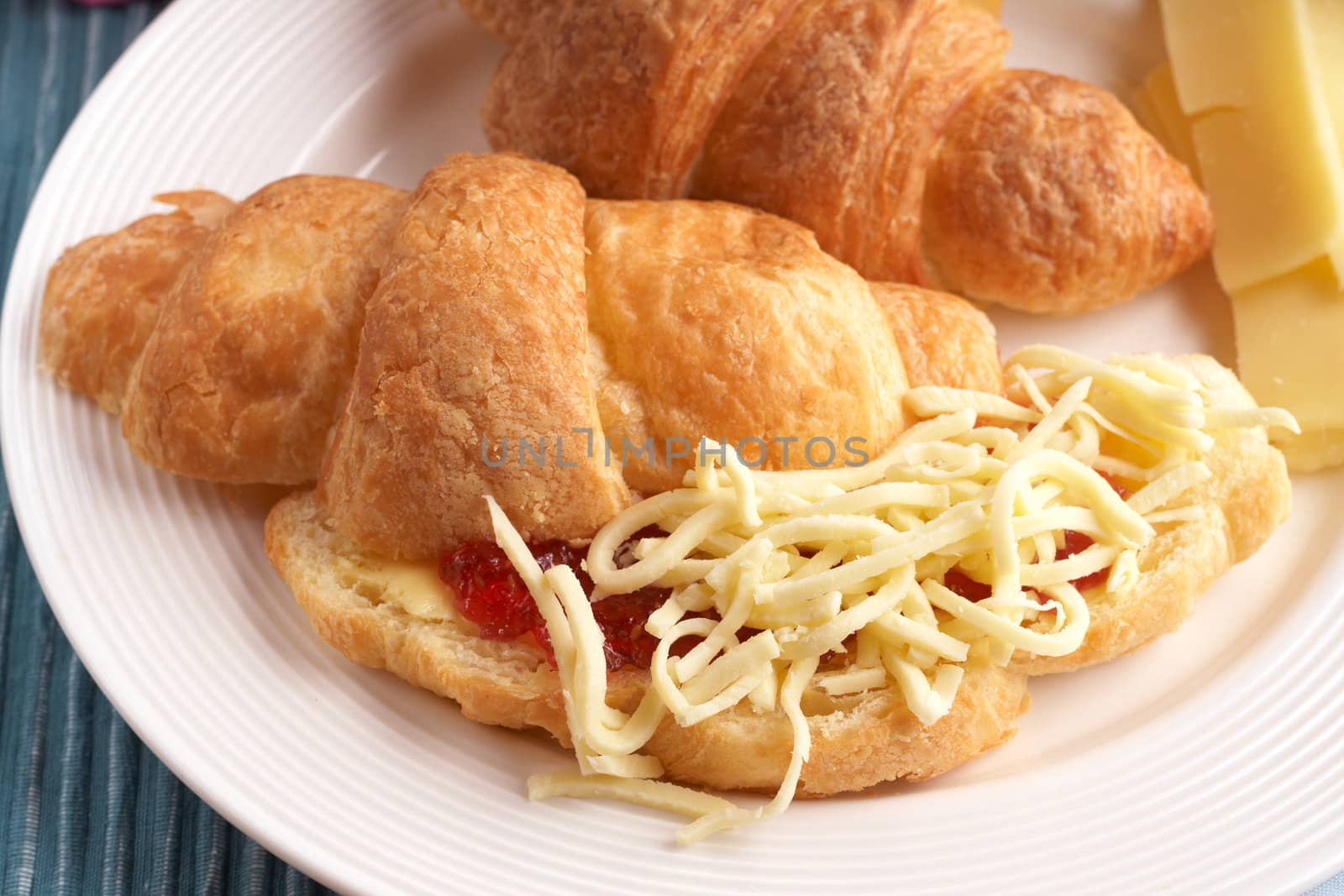 Breakfast plate with freshly baked croissants filled with jam and grated mozzarella cheese