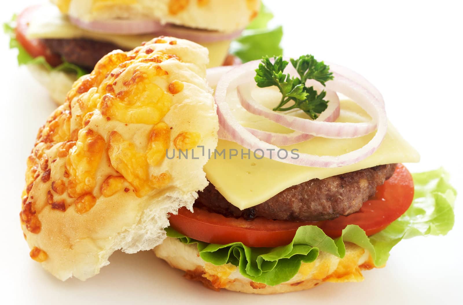 Tasty hamburgers with grilled patty, tomato, cheese and lettuce on white background