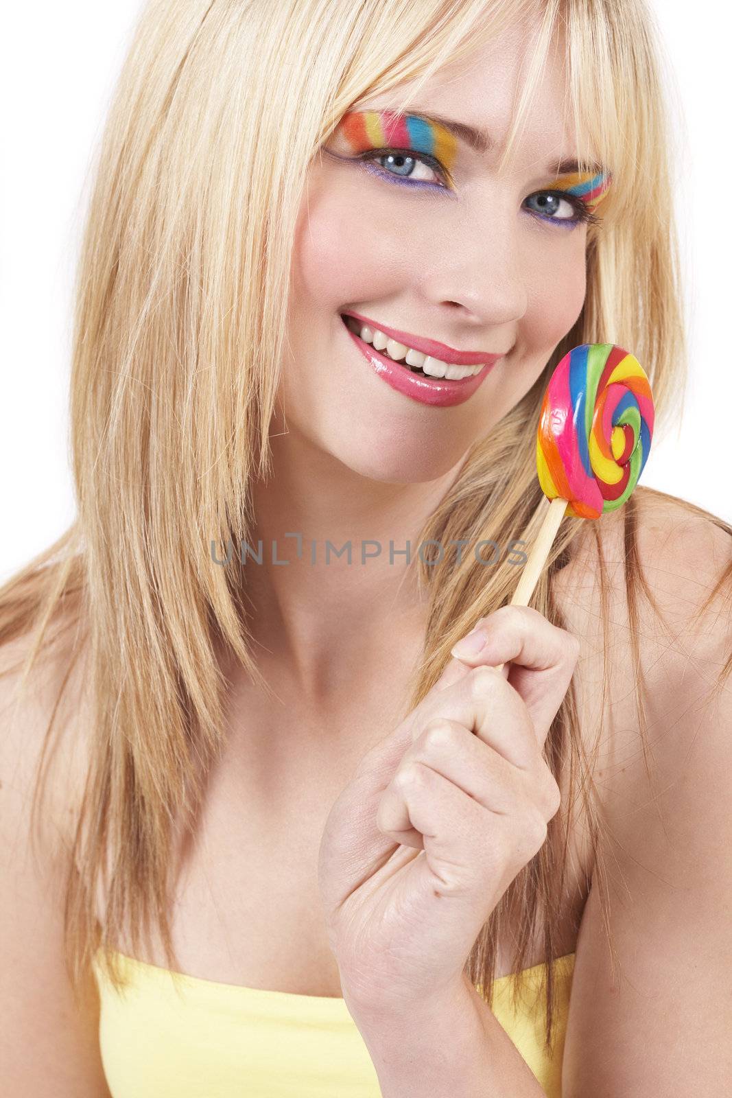 Beautiful blonde woman with colorful eye make-up holding a lollipop isolated on white background